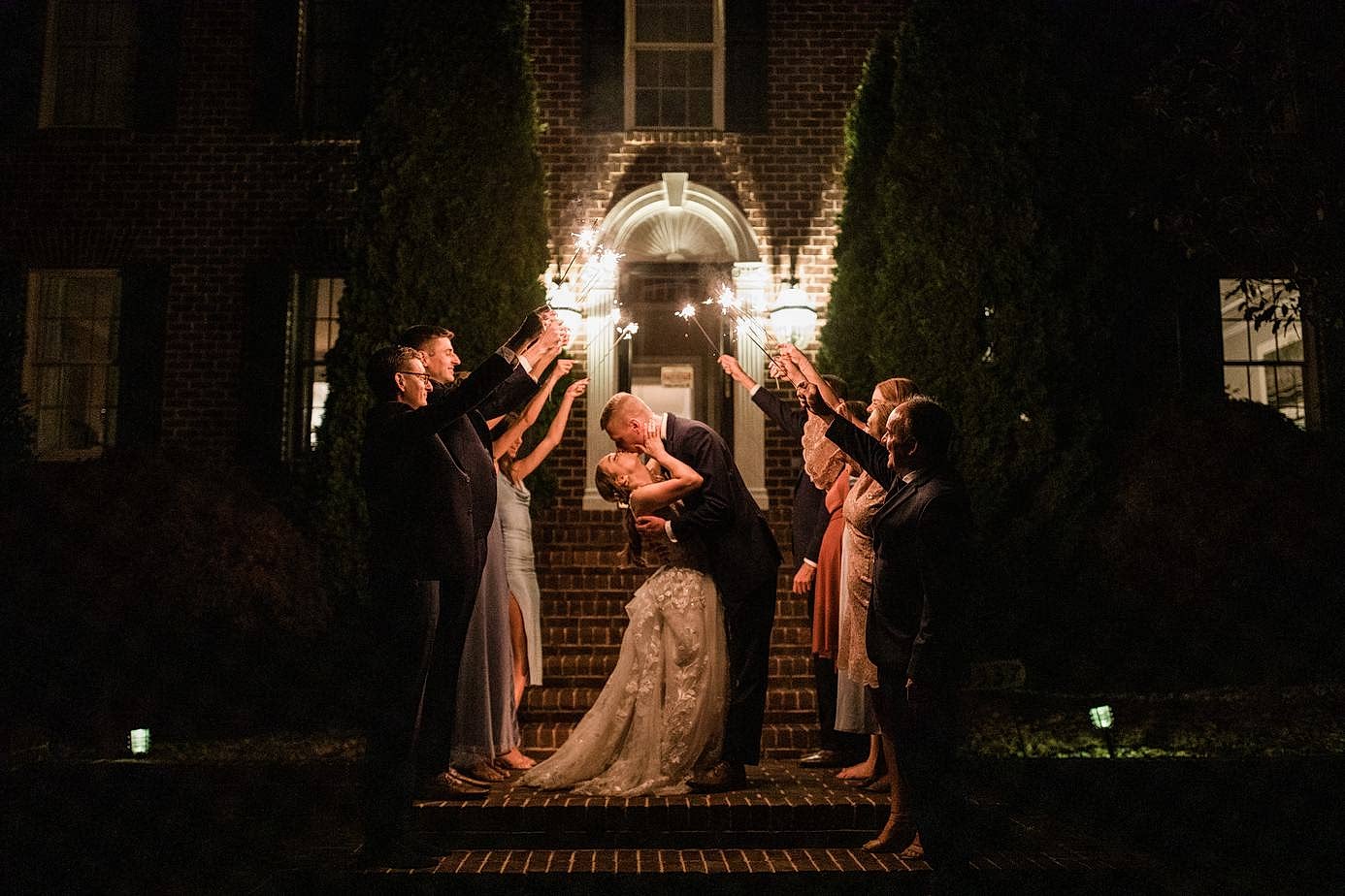 A couple kiss after doing a sparkler exit after their intimate airbnb wedding