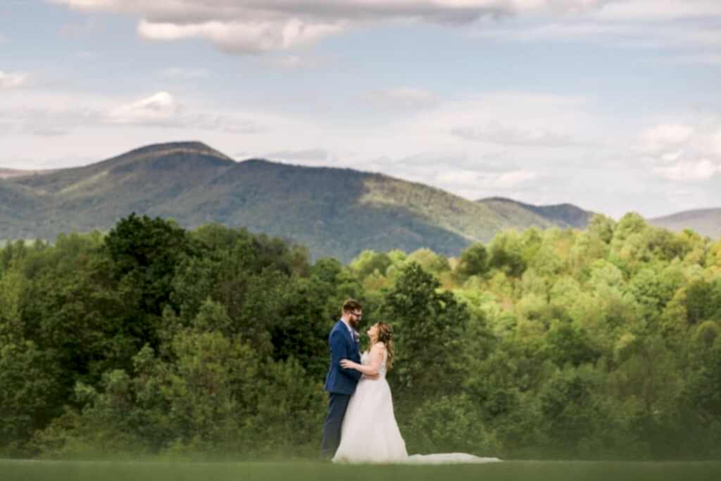 A couple stands in front of a mountain at House Mountain Inn -- one of the best mountain wedding venues in Virginia 