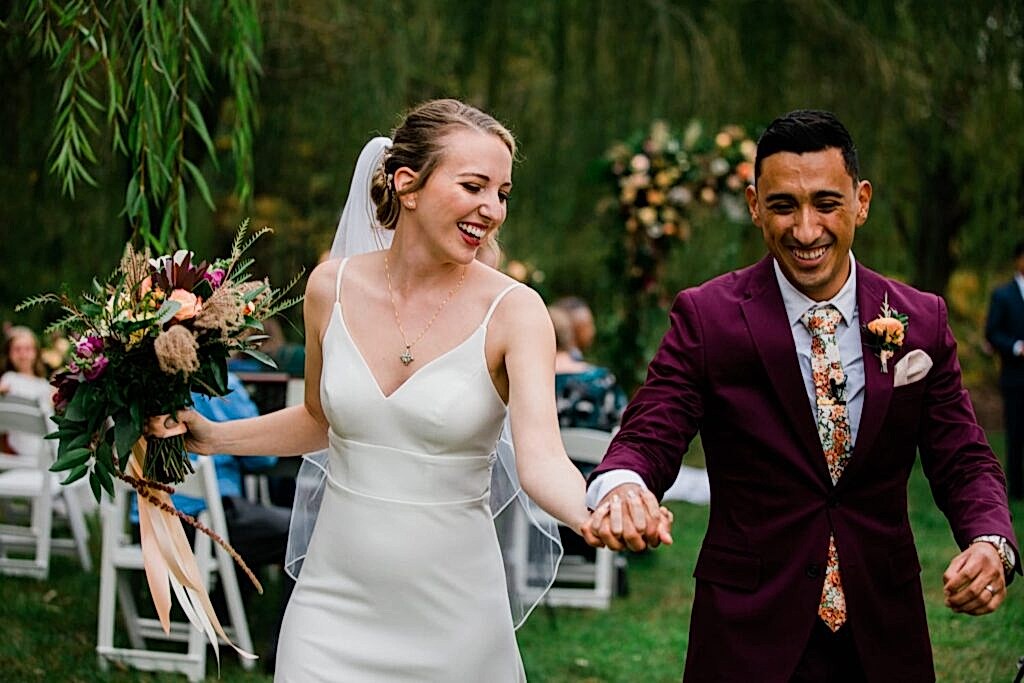 A couple exits their ceremony during their Clyde Willow Creek Farm micro wedding